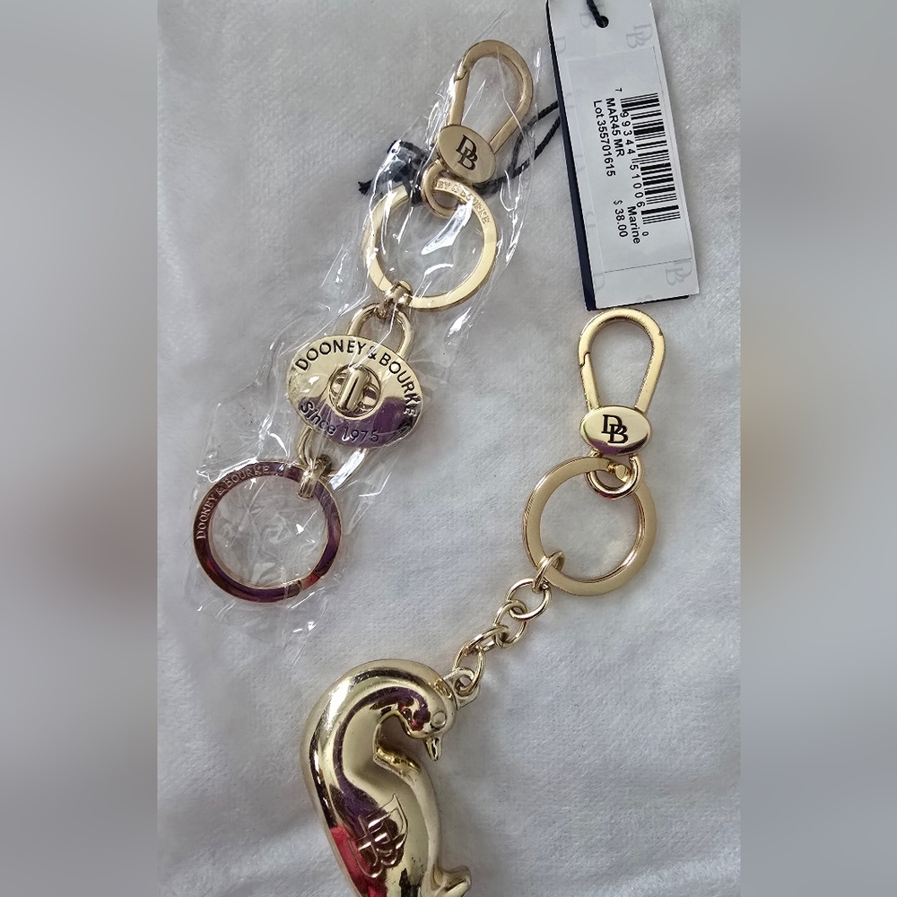 (Two) Dooney & Bourke Gold Duck & Signature Ring Key Fobs